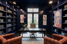 an office with blue walls and leather chairs