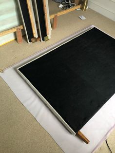 a black and white rug on the floor in front of a wall with wooden frames