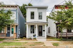 three houses in the same neighborhood, one is white and the other has blue siding