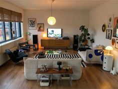 a living room filled with furniture and a flat screen tv on top of a wooden table