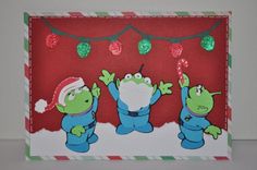 a card with three cartoon characters on it and christmas lights hanging from the ceiling behind them