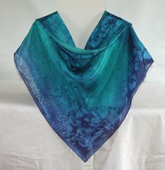 This square silk scarf measures 35 by 35 inches or 90 by 90 centimeters. It will drape around the shoulders or go over the head. It has hand rolled and hand stitched edges into which I sew my own label. The scarf is hand washable and washing instructions are included. I sprayed ponge 5 silk with emerald green and navy blue steam fix dyes. I dropped salt onto the wet dye and then I applied heat which makes the salt pull the dye into a unique pattern. The scarf was then steamed to fix the dye. A s Blue Elegant Rectangular Silk Scarf, Elegant Blue Rectangular Silk Scarf, Elegant Blue Square Silk Scarf, Blue Square Scarves For Gifts, Blue Silk Scarf As Gift, Blue Square Scarves As Gift, Silk Square Scarf, Square Silk Scarf, Scarf Silk