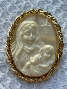 Mother Mary and Baby Jesus carved resin in a gold tone setting.  Can be worn as either a brooch or pendant.  Marked Jane 1997 AOL on the back.  Very good condition.  Measures approximately 2". Gold Brooch With Large Pendant As Gift, Vintage Gold Carved Brooches, Collectible Carved Gold Brooches, Carved Gold Brooch For Gift, Carved Gold Brooches For Gift, Carved Gold Brooches As Gifts, Mary And Baby Jesus, Cameo Brooch, Baby Jesus