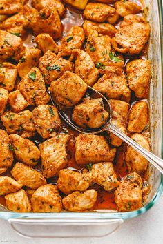 a glass casserole dish filled with chicken and garnished with parsley