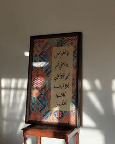 an arabic call written in two different languages on a piece of cloth with a wooden stool underneath it