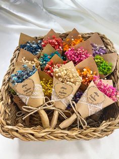 a wicker basket filled with lots of different colored candies in small tags on them