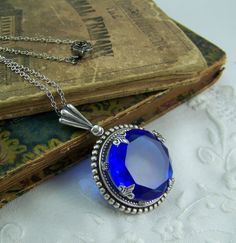 Sapphire Necklace Dark Blue Faceted Stone by CreatedinTheWoods Formal Blue Locket Jewelry, Victorian Style Blue Round Pendant Jewelry, Victorian Round Faceted Jewelry, Victorian Faceted Round Jewelry, Antique Blue Sapphire Jewelry, Blue Round Pendant Locket Jewelry, Victorian Blue Gemstone Necklace, Antique Blue Locket Jewelry, Blue Victorian Locket Jewelry