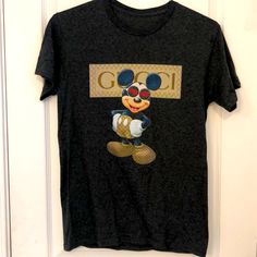 a mickey mouse t - shirt hanging on a door with the word go printed on it