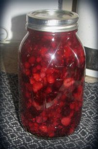 a jar filled with red liquid sitting on top of a table