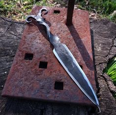 a knife sitting on top of a piece of metal