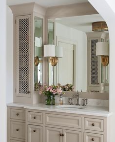 a bathroom with two sinks and large mirrors on the wall above it is decorated in white