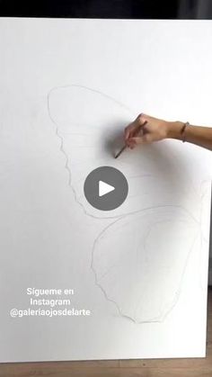 a person drawing on a white board with a butterfly drawn on the wall next to it