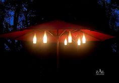 an umbrella is lit up at night with four lights on the top and one in the middle