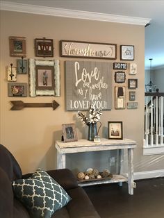 a living room filled with furniture and framed pictures on the wall above it's coffee table