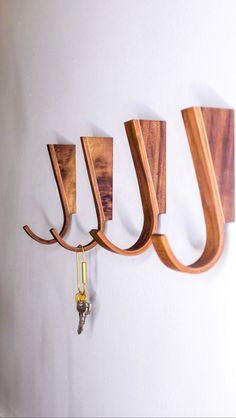 three wooden hooks are hanging on the wall