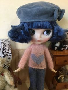 a doll with blue hair is standing next to teddy bears and other stuffed animal toys