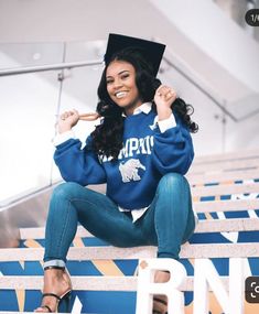 a woman sitting on the bleachers wearing a cap and gown