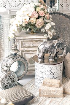 an elephant figurine sitting on top of a table next to a vase filled with flowers