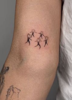 a woman's arm with three dandelions on it