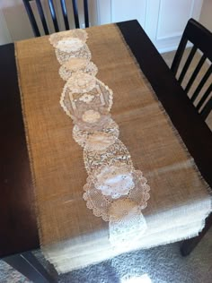 the table is covered with doily and has a lace runner on top of it