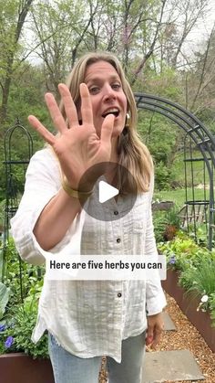 a woman standing in front of a garden holding her hand up to the camera and saying, here are five herbs you can grow