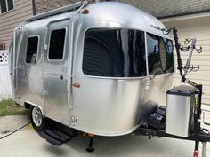 a silver trailer parked in front of a house