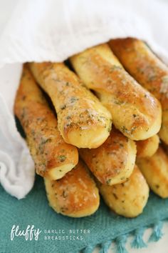 some bread sticks are piled up on a towel