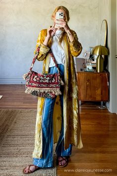 I'm new to mixing prints but I find if I follow color theory the prints almost don't matter, but I'm still getting the hang of it. Loved this easy boho daisy jones outfit with a long velvert duster kimono jacket and a pair if linen pants with my thrifted carpet bag #daisyjones #bohoaesthetic #mixingprints #outfitideas Silk Duster Outfit, Outfits With Kimonos, Bohemian Woman, Duster Jacket Outfit, Fall Kimono Outfit, Formal Boho Outfit, Kimono Over Dress Outfits, Carpet Bags, Boho Corporate Outfit