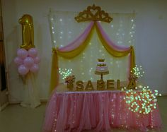 a table topped with a cake surrounded by pink tulle skirted skirts and balloons