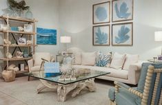 a living room filled with furniture and pictures on the wall next to a coffee table