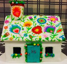 a cake decorated like a house with flowers on it