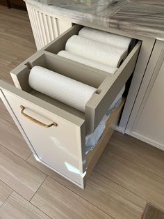 an open drawer with two rolls of toilet paper in it and one roll of tissue on the bottom