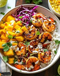 a white bowl filled with rice and shrimp next to other food on top of a wooden table