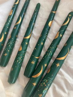 six green and gold stars and moon painted baseball bats