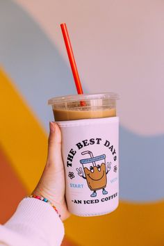 a person holding up a coffee cup with a straw in it's mouth and the words, the best day is start an iced coffee