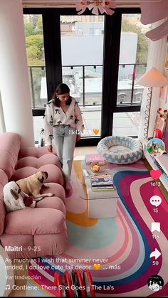 a woman standing next to a dog on top of a pink couch in a living room