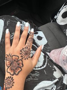 a woman's hand with henna tattoos on it