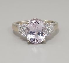 Add a touch of elegance to your jewelry collection with this stunning 14k white gold ring. Featuring a 10x8mm light pink kunzite gemstone and 10 sparkling diamonds, this ring is perfect for any occasion. The oval-shaped kunzite is complemented by a white gold band, while the diamonds add a touch of sparkle to this beautiful piece. With a ring size of 6.5. weight of 4 grams. This ring is a statement piece that is sure to catch the eye of anyone who sees it. The pink kunzite is the perfect color for anyone who loves pink, while the diamonds add a touch of luxury to the piece. This ring is pre-owned and in great condition, making it a great addition to any jewelry collection. Pink Kunzite, White Gold Band, 14k White Gold Ring, White Gold Ring, Sparkle Diamonds, Gold Band, Diamond Gemstone, White Gold Rings, Gemstone Ring