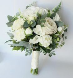 a bridal bouquet with white flowers and greenery