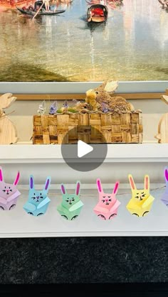 some paper rabbits are sitting in front of a painting