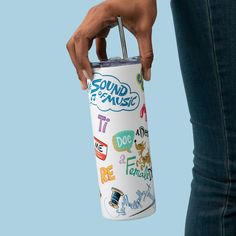 a person holding a white tumbler cup with various stickers all over it and the words sound of music on it