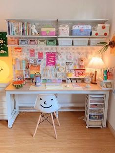 a white desk topped with a chair next to a shelf filled with lots of books