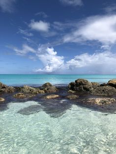 an ocean view with rocks and clear water