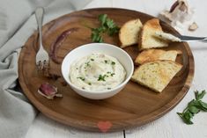 a wooden plate topped with bread and dip