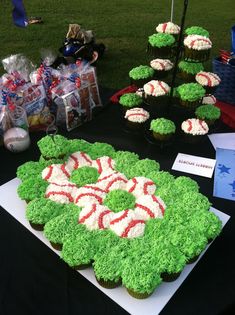 cupcakes are arranged in the shape of a flower on a table at a baseball game