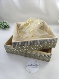 an open box with a yellow ribbon in it on a white tableclothed surface