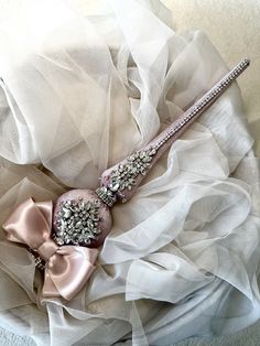 a bridal garter on top of a bed with white fabric and pink flowers