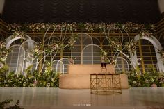 the stage is decorated with flowers and greenery as well as a couch for guests to sit on