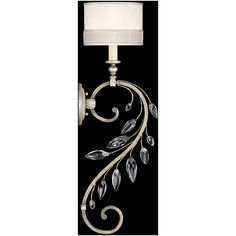 a wall lamp with a white shade on it's side and leaves painted on the back