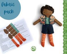 the doll is sitting next to an open book and paper with instructions for sewing on it